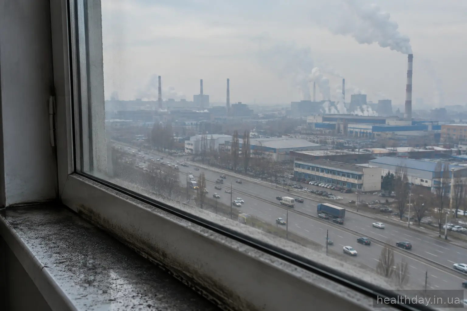 Вікно квартири на тлі промислового району та жвавої траси