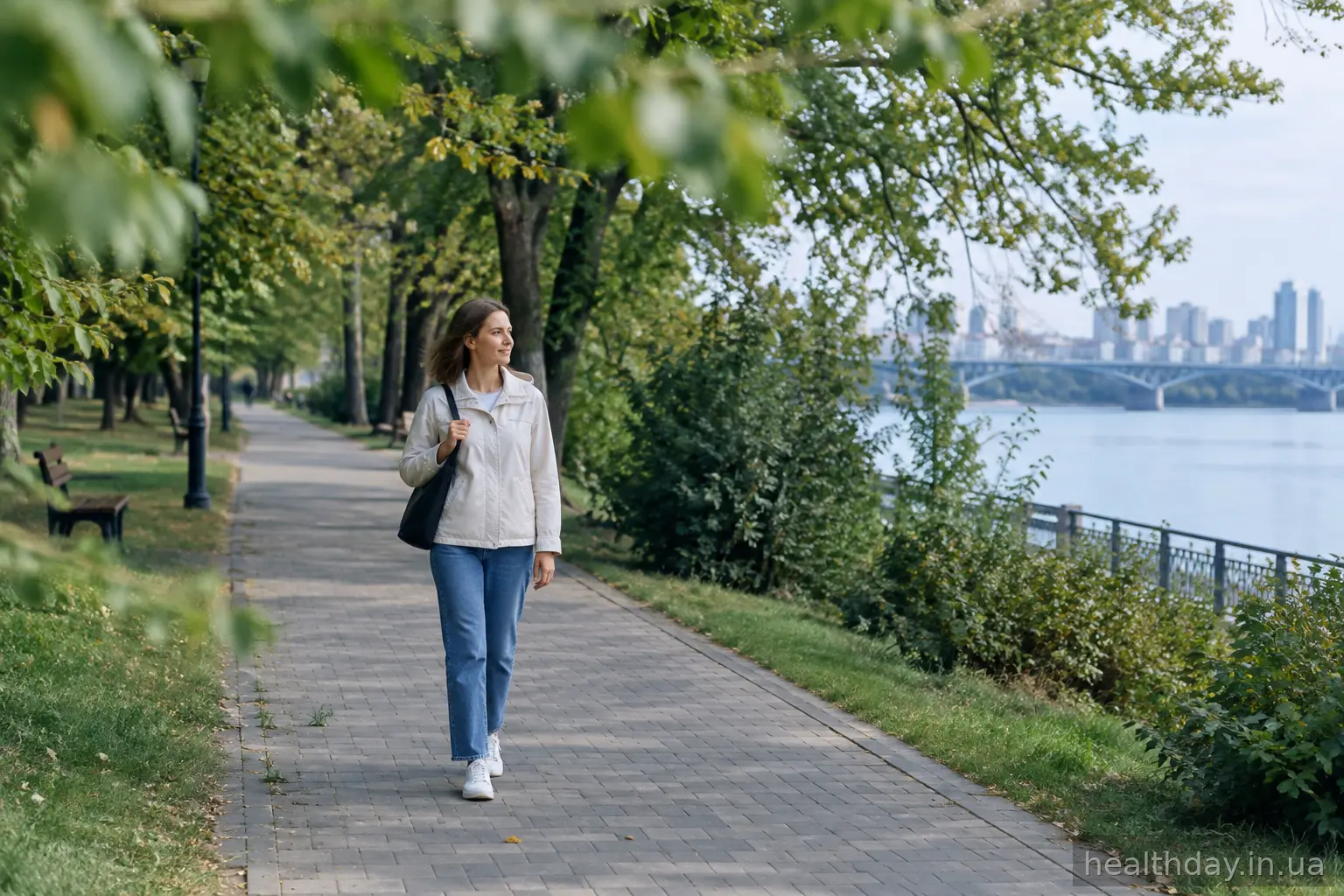 Жінка йде алеєю парку, щоб заспокоїтися на свіжому повітрі